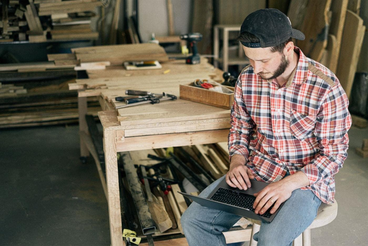 A small business owner using a laptop in his woodworking shop